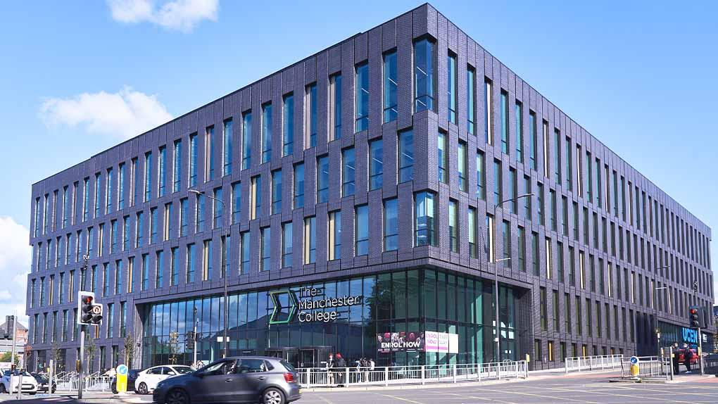 A wide angle shot of City Campus Manchester on a clear day, showing the Manchester College entrance.